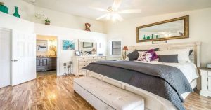Bright and modern bedroom with king-size bed and wooden flooring. 