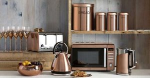 Modern copper kitchen appliances including microwave, toaster, kettle, and containers.