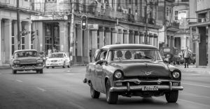 Vintage cars driving on a street in a historic cityscape