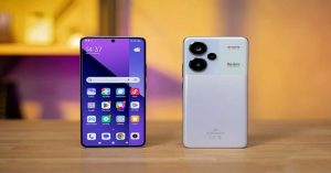 Front and rear view of a white Redmi smartphone on a wooden table with a colorful background.