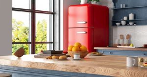 A cozy kitchen with a red retro fridge and wooden accents. 