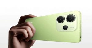 Close-up of a hand holding a green Xiaomi smartphone with a dual rear camera design, displayed on a clean white background.