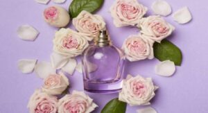 Purple perfume bottle surrounded by pink roses on lavender background.