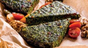 Baked Persian Kuku Sabzi slices with tomatoes and walnuts.