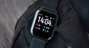 Black square smartwatch showing time and fitness data on a backpack