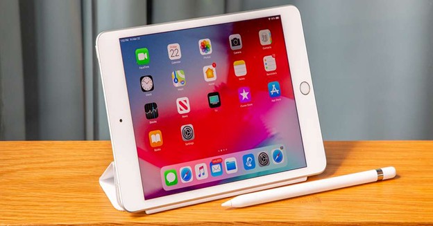 iPad Mini with Apple Pencil on wooden table.