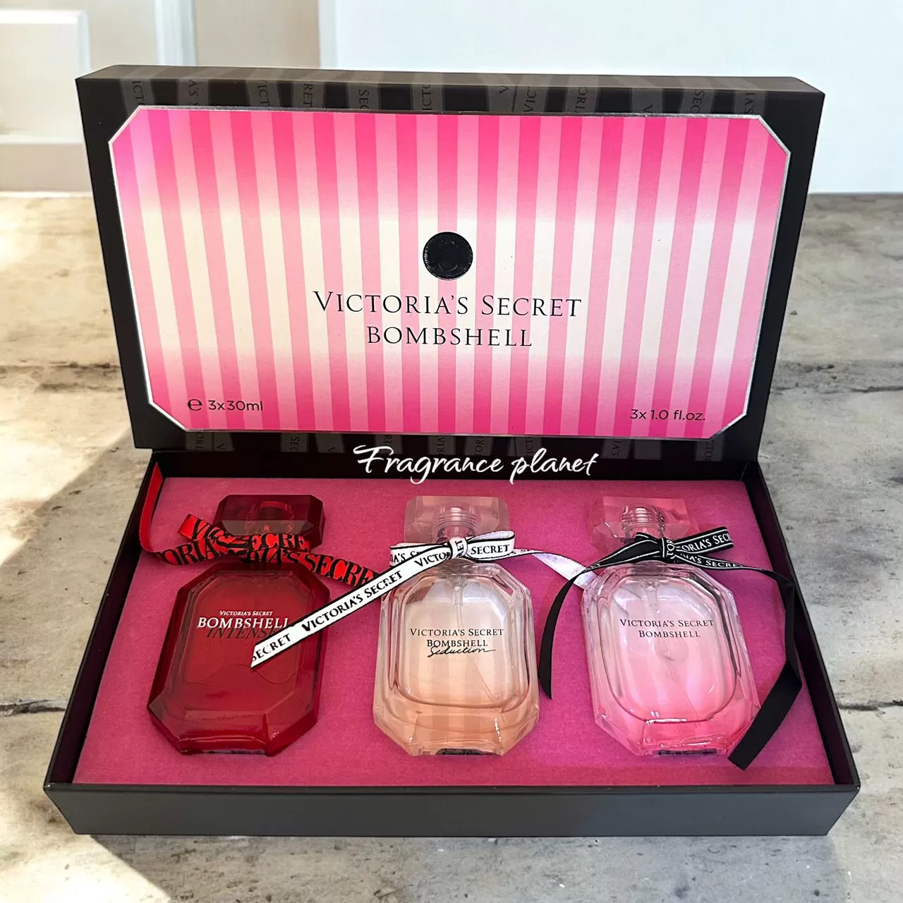 Victoria’s Secret Bombshell perfume gift set with three bottles in a pink presentation box
