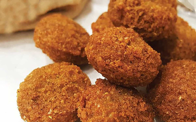 Crispy homemade falafel balls served on a white surface.