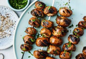 Grilled mushroom skewers garnished with chopped parsley.

