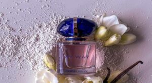 Giorgio Armani My Way perfume bottle with white flowers and vanilla pods on textured surface. 