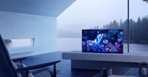 Modern TV displaying crystals in a minimalist lakefront room with panoramic view.
