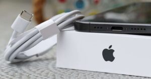 Close-up of iPhone USB-C port and charging cable on Apple box.

