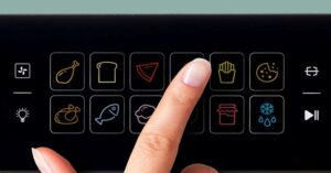 Finger selecting fries cooking mode on an air fryer digital control panel.
