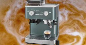 KitchenAid espresso machine with glass cup on drip tray against coffee swirl background.

Ask ChatGPT

