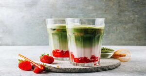 Strawberry matcha latte with layered green tea, milk, and fresh strawberry puree in tall glasses.