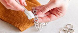 cleaning a silver bracelet with a toothbrush on a cloth