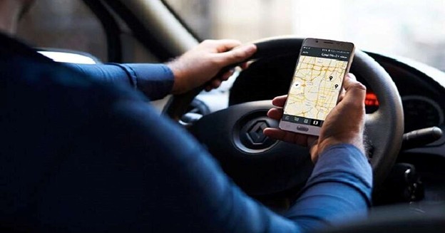 Driver checking navigation map on smartphone while driving a car.