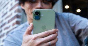 Person holding a green iPhone 17 outdoors
