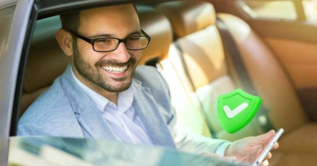 Smiling passenger using smartphone in car with green safety icon.