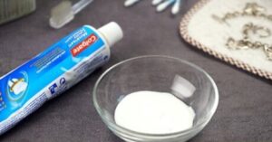 toothpaste and bowl used for cleaning silver jewelry at home