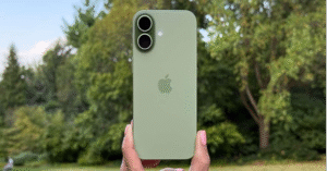 Green iPhone 17 held outdoors with trees in background