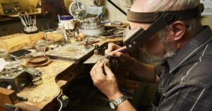 jeweler polishing a silver ring at a workbench using professional tools