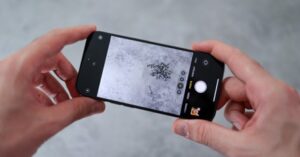  Hands holding a smartphone and taking a close-up picture of metal objects.