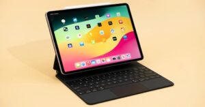 iPad Pro with Magic Keyboard accessory displaying the Home Screen and apps.