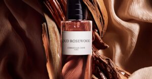 Elegant bottle of Oud Rosewood Christian Dior perfume surrounded by wood pieces.