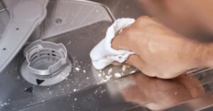 Cleaning the dishwasher filter area to remove food residue and prevent stains