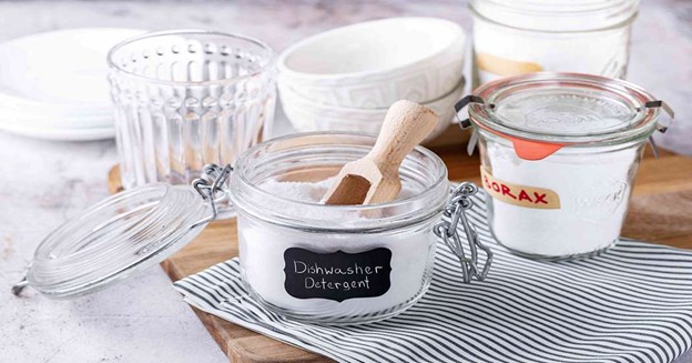 Homemade dishwasher detergent powder stored in glass jars with borax and cleaning ingredients
