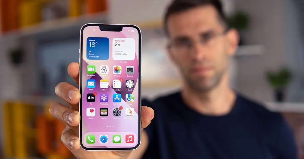 iPhone held in hand with home screen displayed