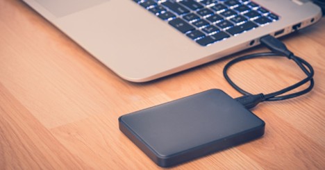 External hard drive connected to a laptop via USB cable