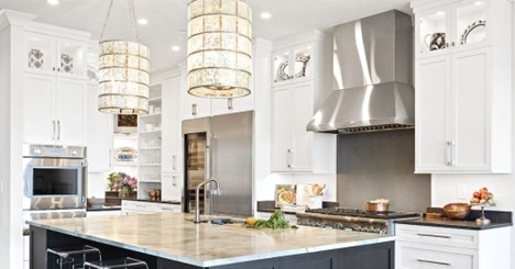Modern kitchen with large refrigerator, oven, range hood, and pendant lights
