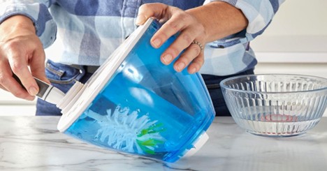 Person cleaning a humidifier water tank with a brush