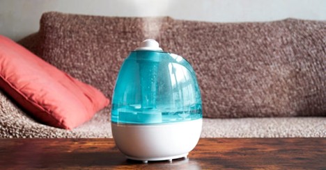 Blue and white humidifier on a wooden table in a living room
