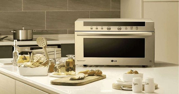 LG speed oven on kitchen island with cooking ingredients, utensils, and modern home decor