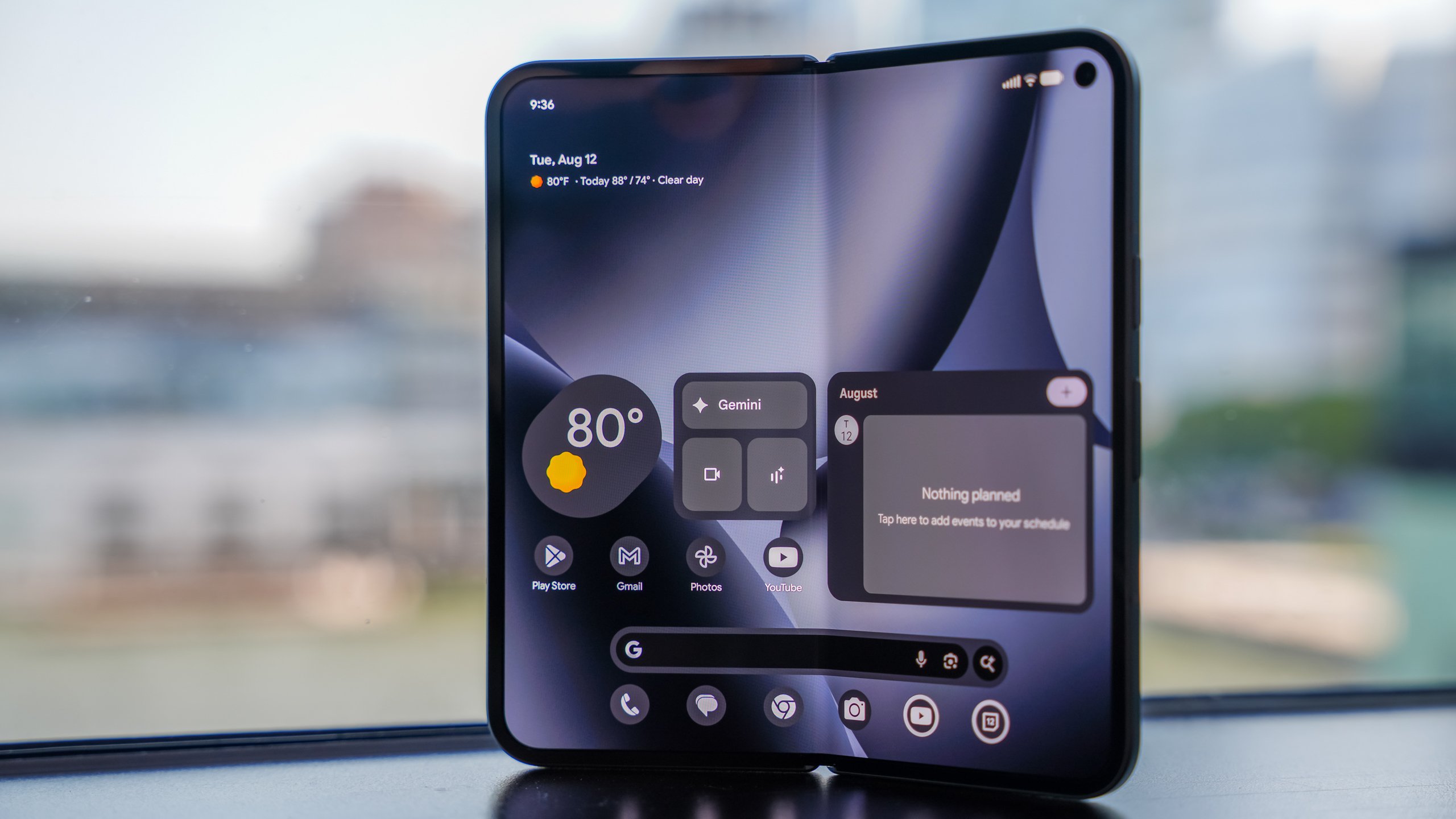 Google Pixel Fold smartphone in open tablet mode displaying Android widgets, Gemini AI features and multitasking interface on a large foldable screen. 