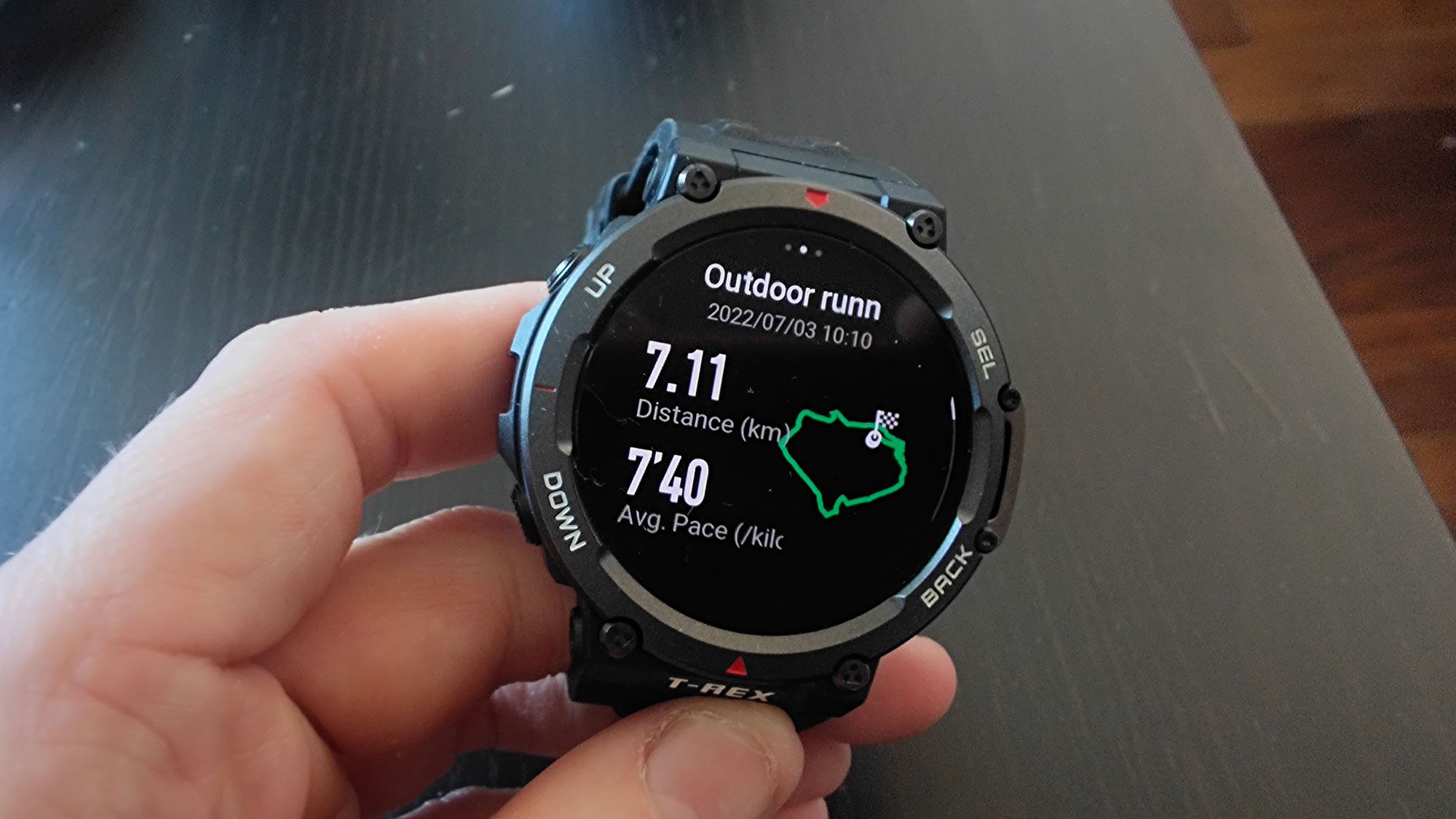 Rugged round smartwatch showing outdoor running distance and pace data 