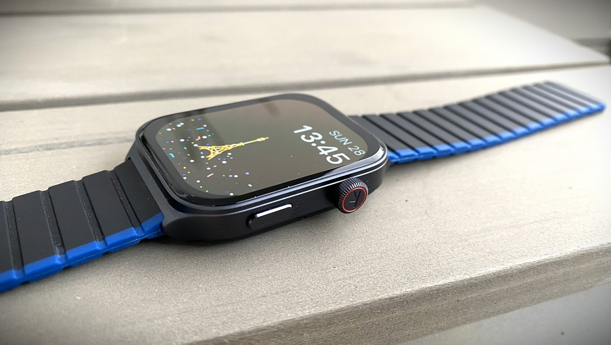 Rectangular smartwatch with blue and black strap lying on a light surface 
