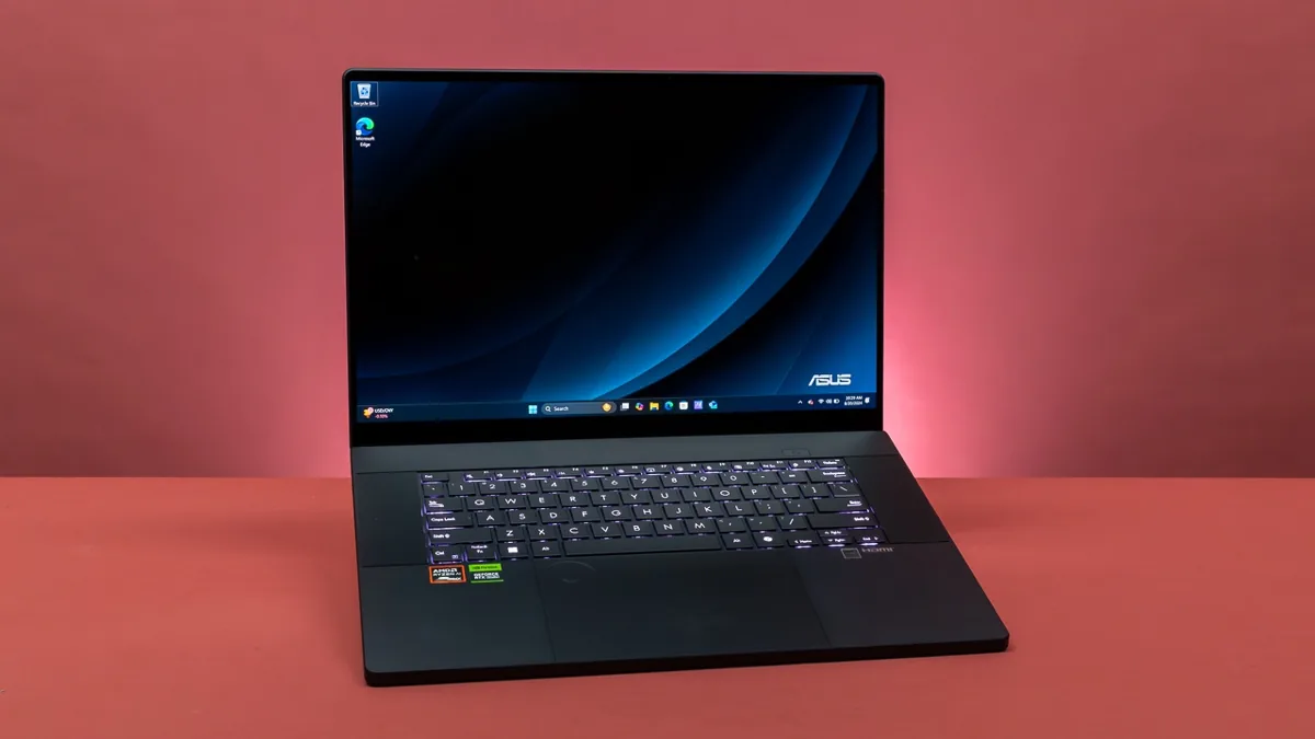 Black ASUS laptop with Windows display on red desk background