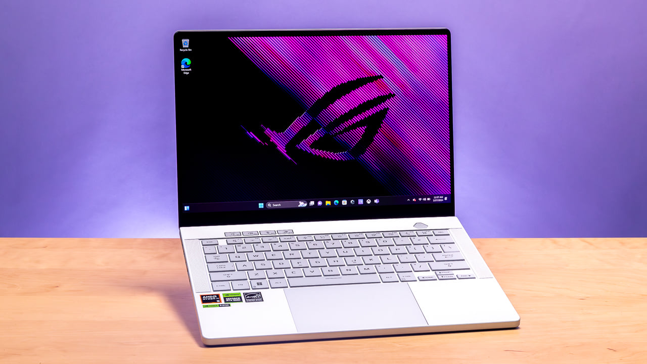 White ASUS ROG gaming laptop with Windows display on wooden desk