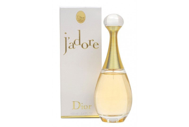 Dior J’adore perfume bottle with white and gold packaging on a plain background

