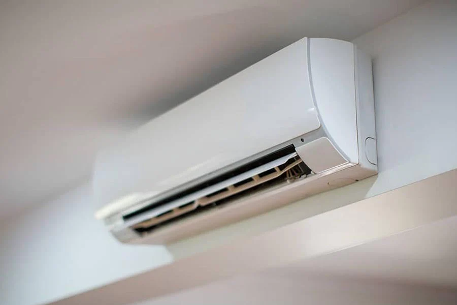 Wall-mounted split air conditioner installed on an indoor wall with open vents 