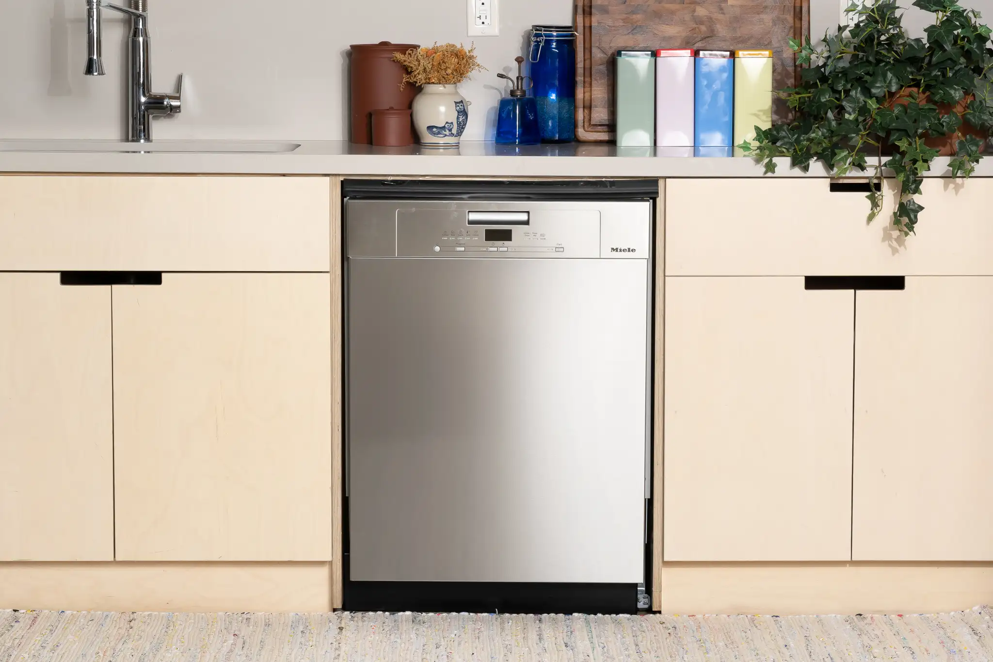 Built-in stainless steel dishwasher installed beneath a modern kitchen countertop