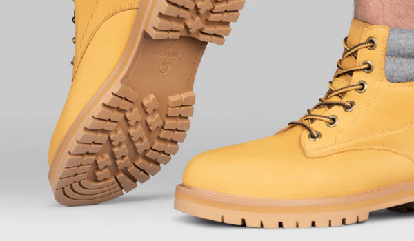 Yellow leather boots showing rugged soles and lace-up design.