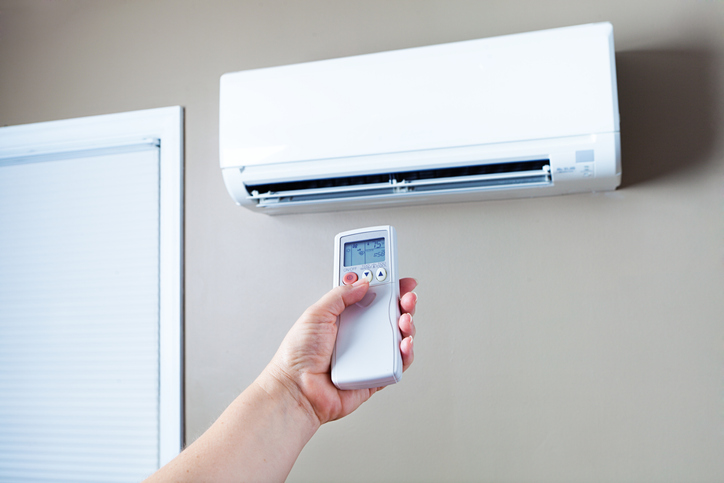 Wall-mounted air conditioner with remote control in a modern indoor setting 