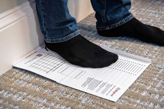Measuring foot length on a printable sizing chart for accurate online shoe size selection
