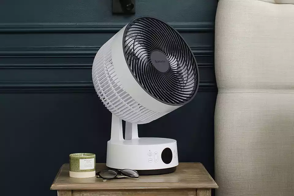 White table fan placed on a side table in a modern bedroom interior
