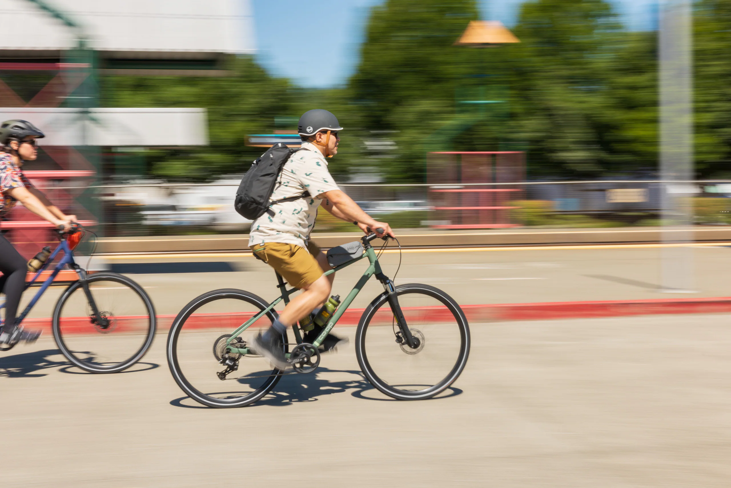 Cyclists wearing helmets riding bicycles on a city street.